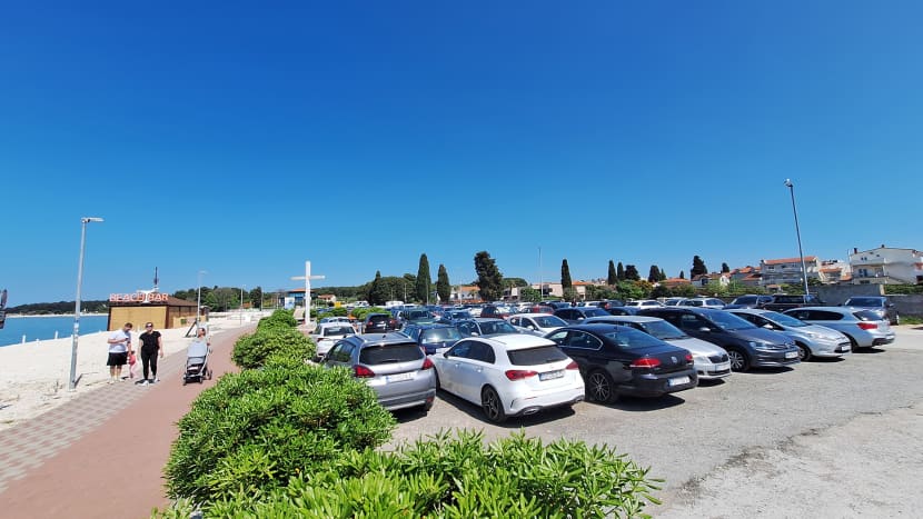 Vozila parkirana na parkiralištu Badel uz plažu u Fažani