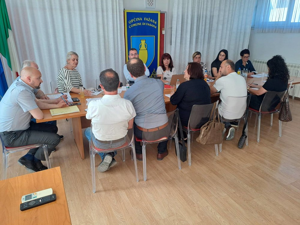 Vijećnici za stolom na 10. radnoj sjednici Općinskog vijeća Fažana, ispred grba Općine Fažana