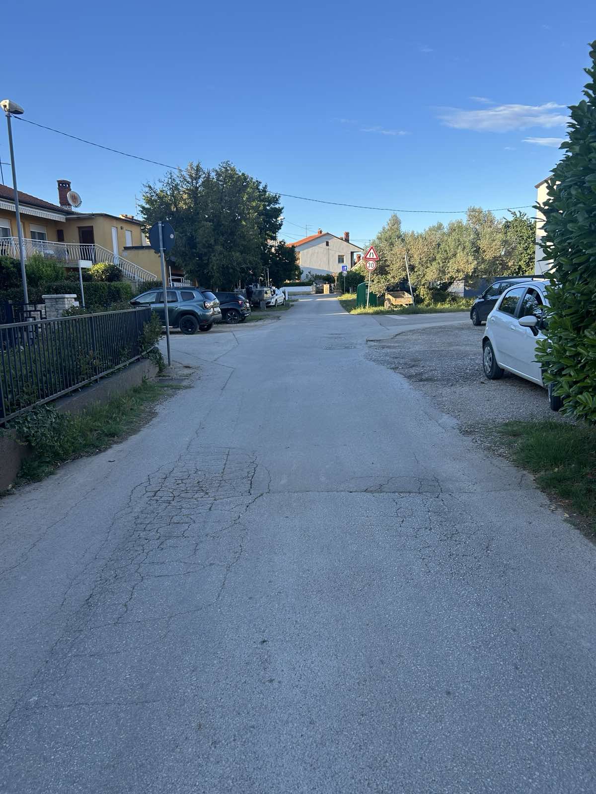 Vlačićeva ulica s parkiranim vozilima uz rub i prometnim znakom u daljini