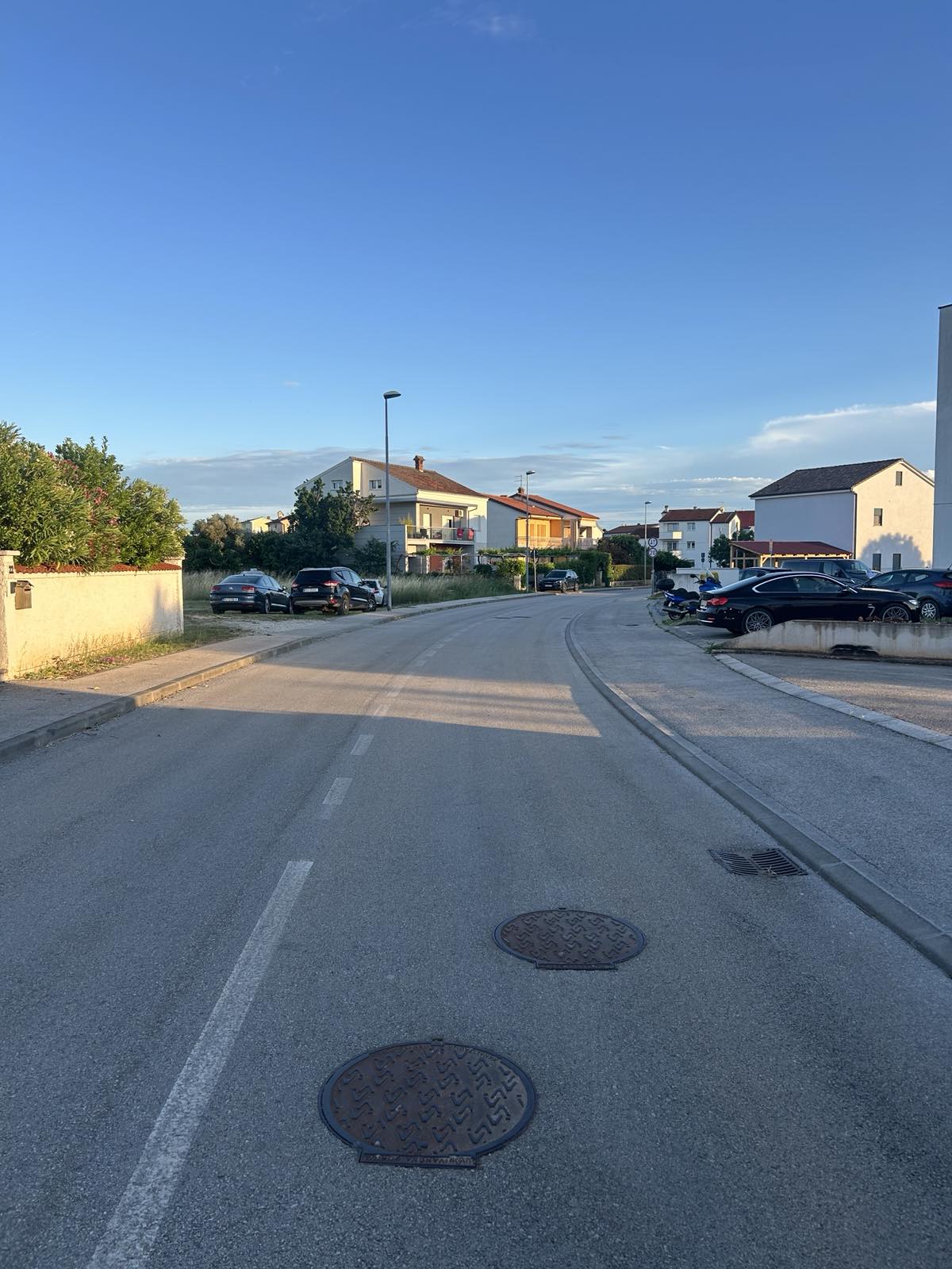 Vlačićeva ulica s poklopcima šahtova na kolniku, bez obilježenog pješačkog prijelaza